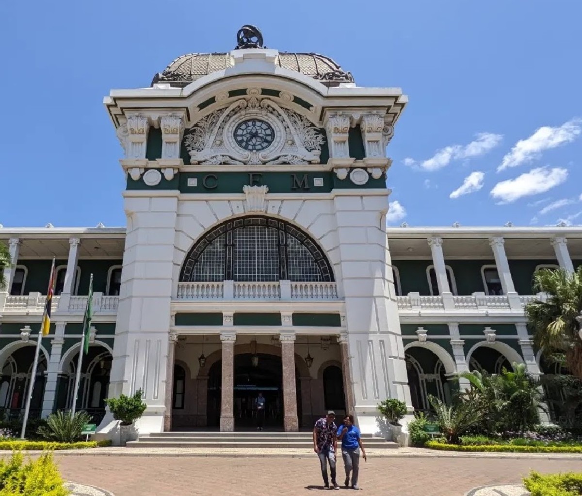 Two people walking out of Maputo's historic train station.