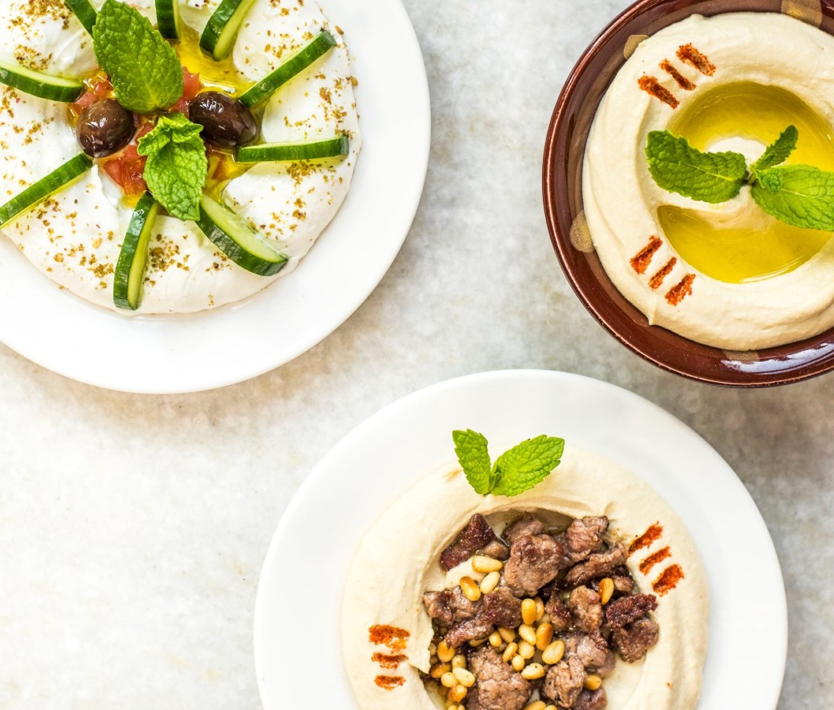 Three plates of hummus and spreads