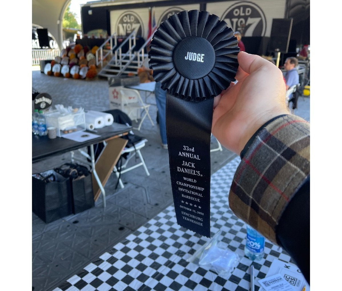 Hand holding a "Judge" ribbon at the the Jack Daniel's barbecue competition.