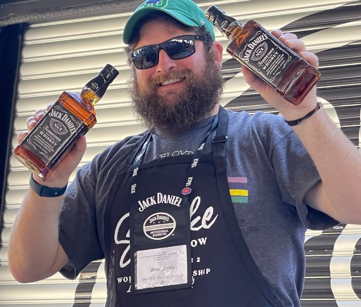 Brad Japhe, writer and judge at the Jack Daniel's BBQ competition. Holding two bottles of Jack Daniel's whiskey.