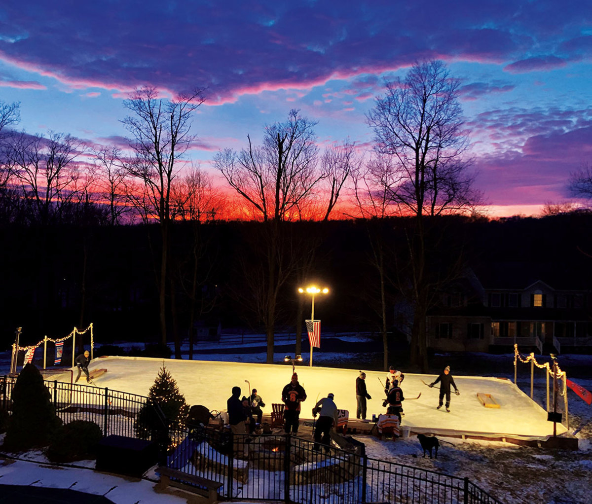 Aerial view of kids playing on outdoor hockey rink at sunset