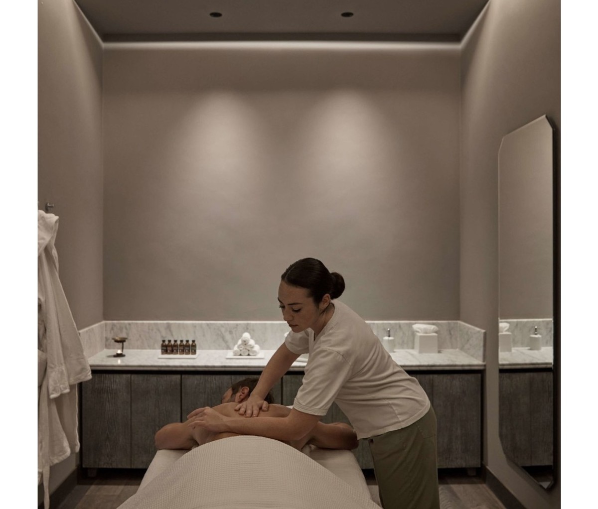 Woman massaging man in dimly lit room