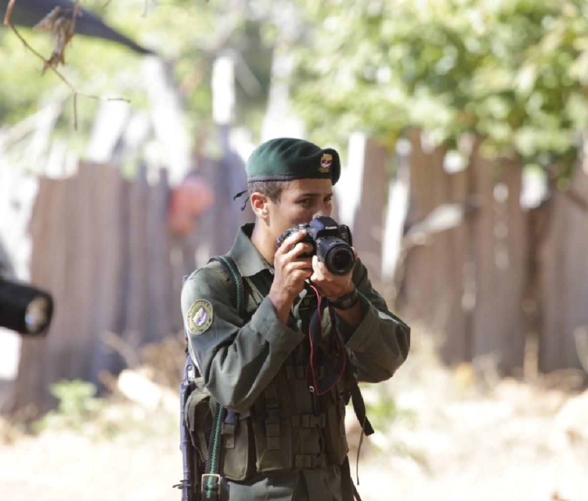 Guerilla-turned-bird guide Marcos De La Oz, holding a camera in army fatigues.