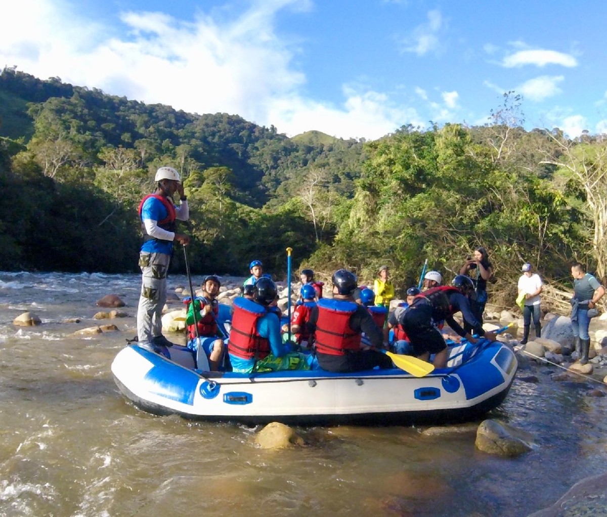 Group of rafters sitting in a boat on a river in Colombia.
