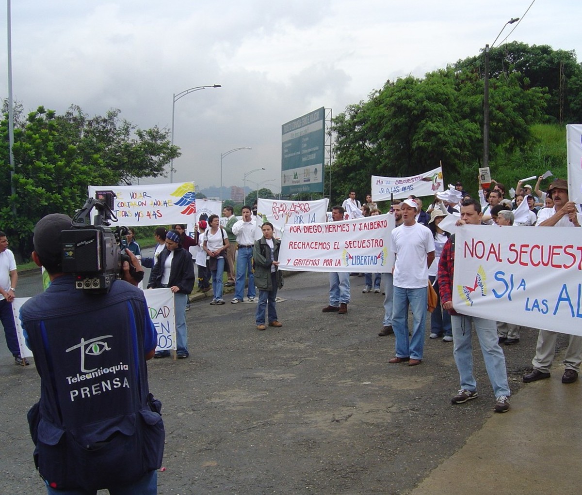 Protesters on a city street in Colombia holding picket signs.