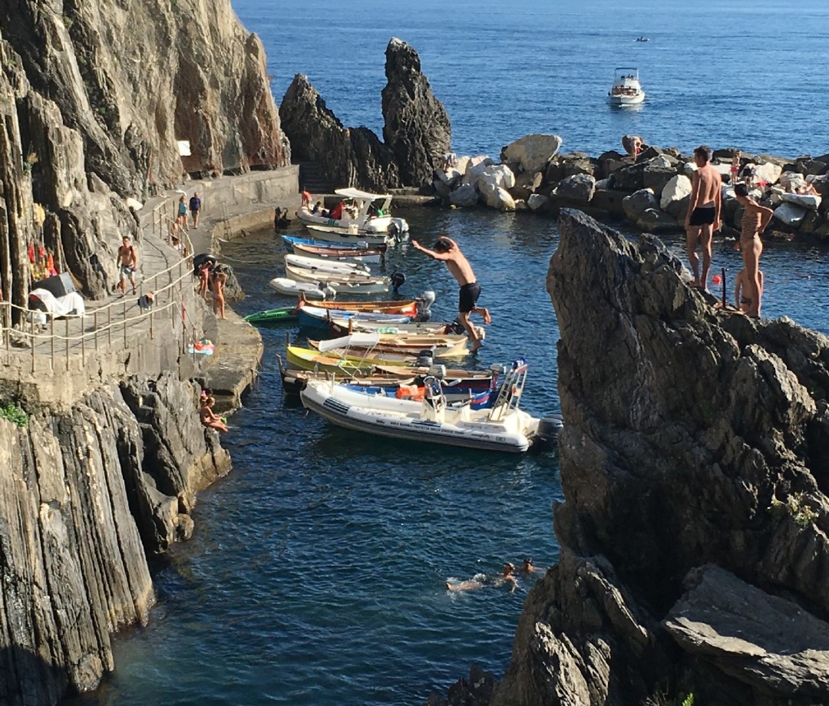 Local jumping off a cliff into the water on the coast of Manarola