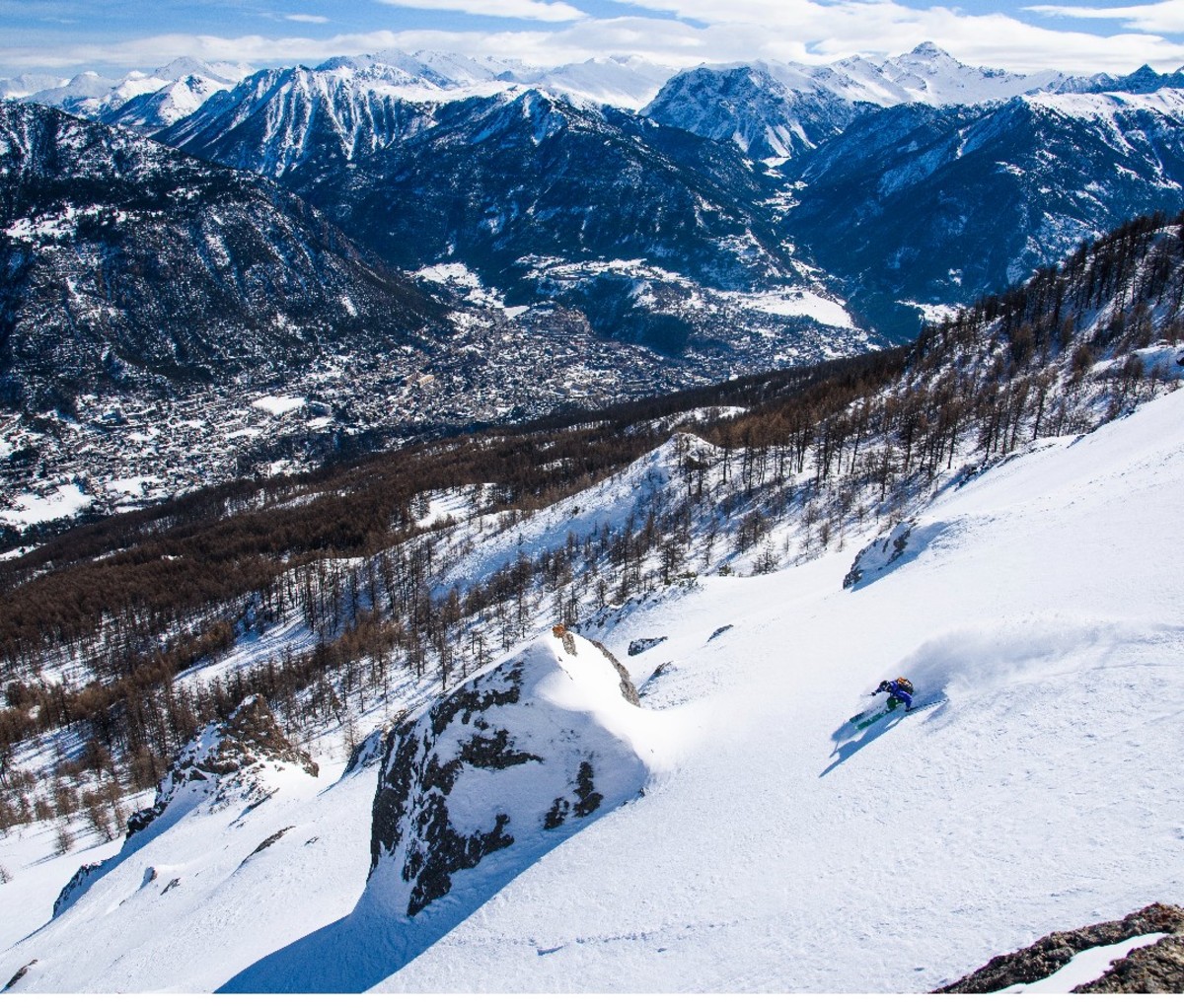Long shot of skier on a powdery slope, European alps.