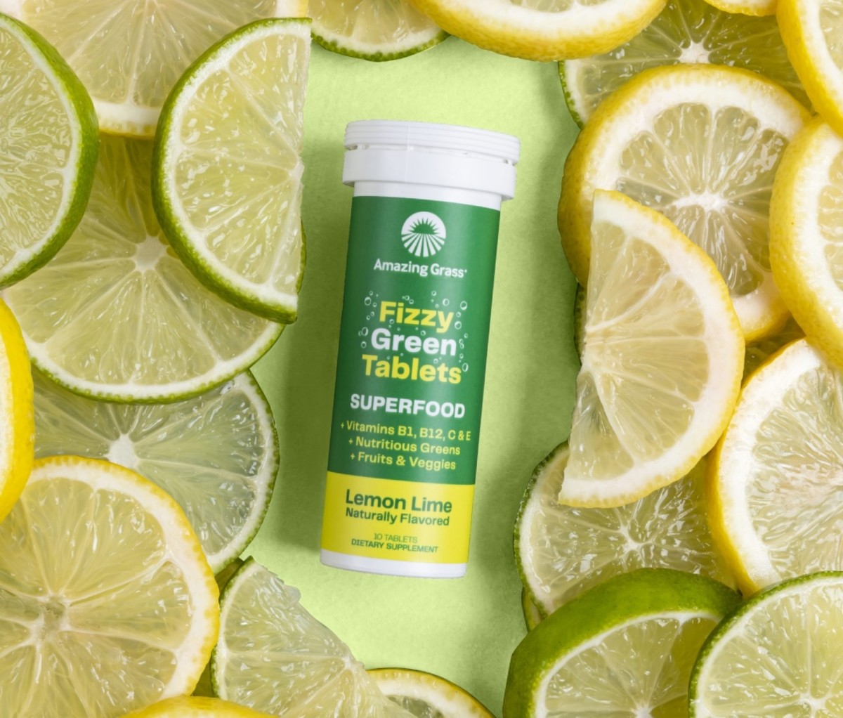 Bottle of Amazing Grass Fizzy Green Tablets with limes and lemons surrounding it