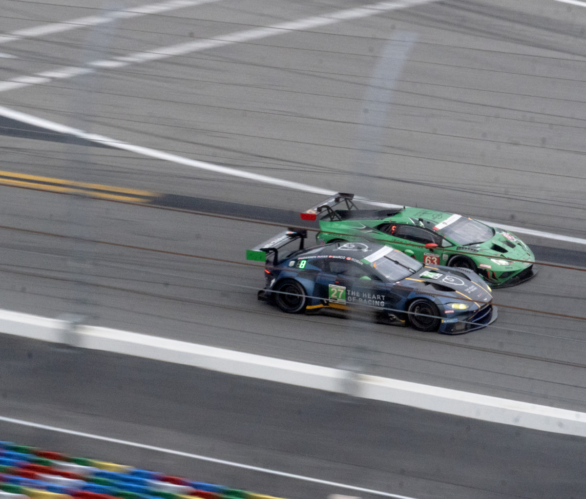 Two race cars driving next to each other at the Rolex 24 at Daytona endurance race.