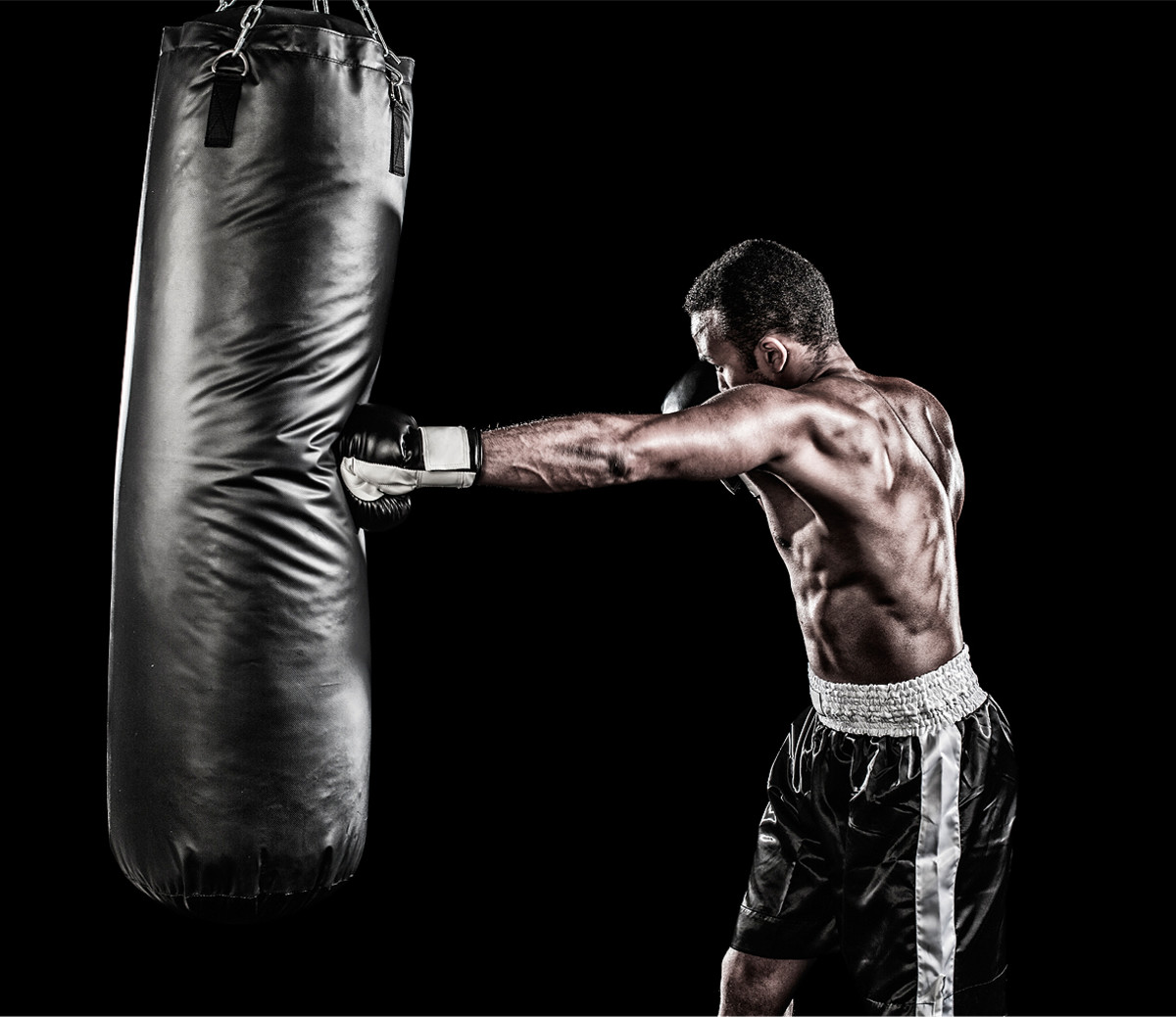 Cross Punch - A man performing a cross punch in a punching bag.